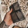 grey tobacco pouch in a hand with tattoo