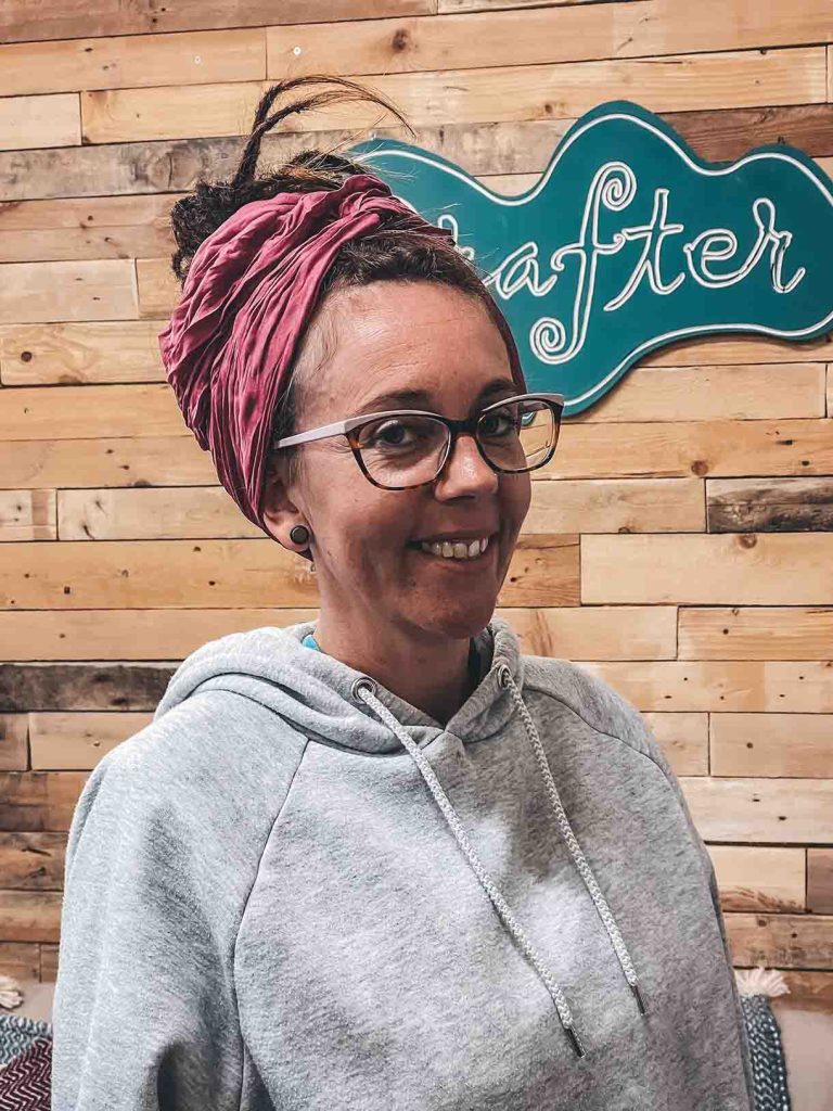 Dreadlock Bun with a raspberry scarf on a smiling female with glasses