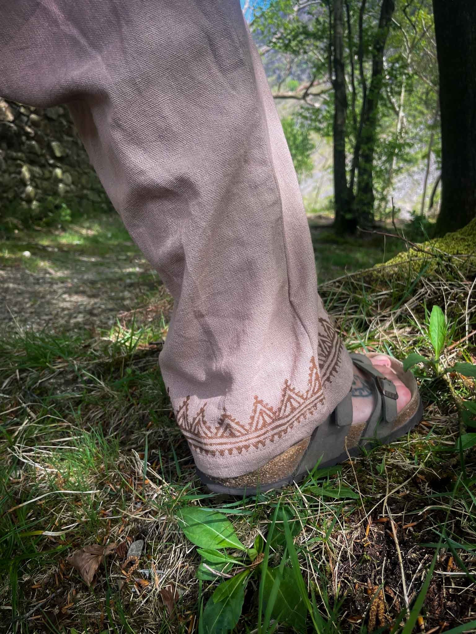 beige jumpsuit with blockprint detail on a foot wearing birkenstock sandals