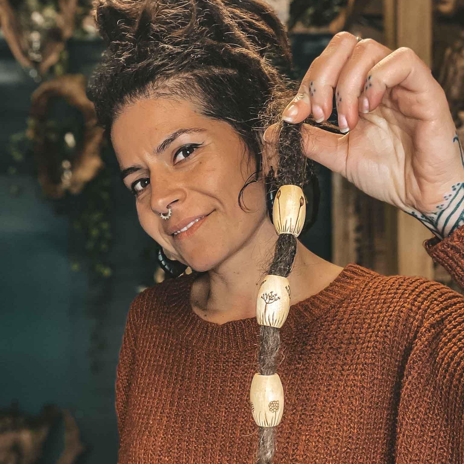 Botanical Wooden Dreadlock Beads crafterelena person showing the Botanical Wooden Dreadlock Beads Large handmade beads with weeds elderflower and poppy pyrography design