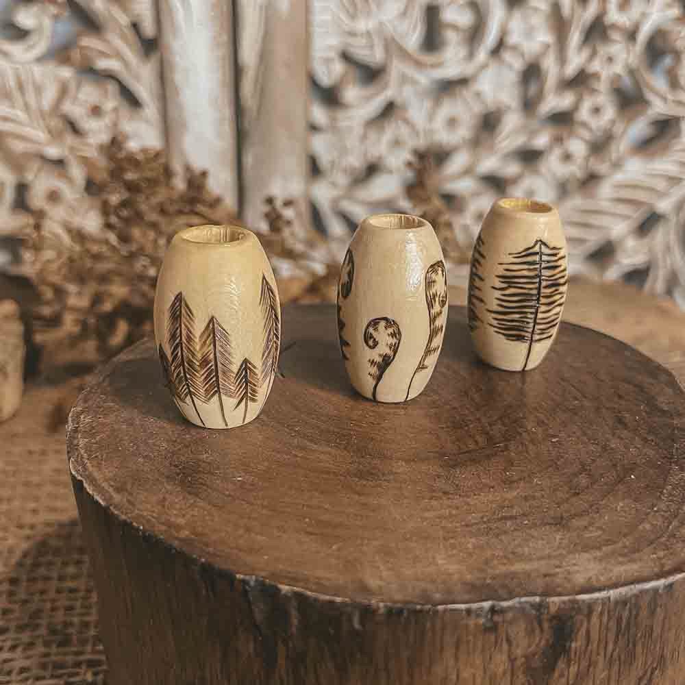 deep forest hand burned design with pyrography technique on 3 large wooden dreadlock beads on an angle